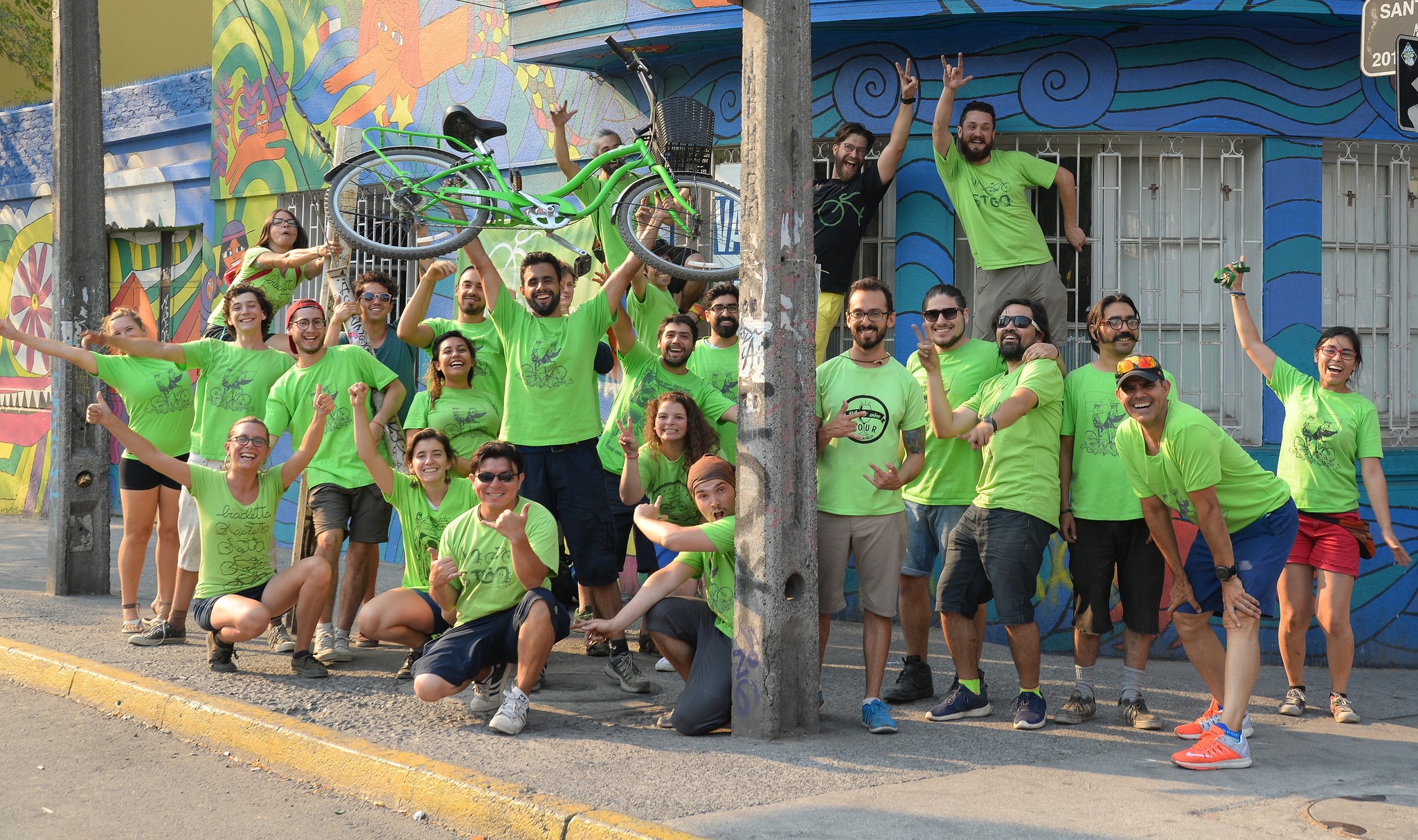 La Bicicleta Team clad in green shirts posing in front of their business building